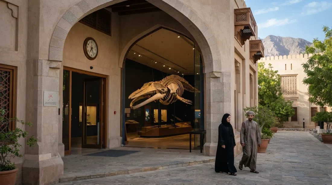 entrada del Museo de Historia Natural de Omán en el complejo del Ministerio de Patrimonio, con el esqueleto montado de ballena esperma visible en una galería compacta y con luz tenue